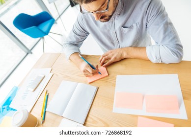 Attentive office worker writing notes