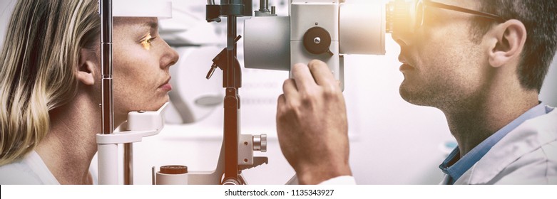 Attentive optometrist examining female patient on slit lamp in ophthalmology clinic - Powered by Shutterstock