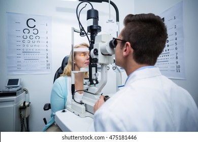 Attentive optometrist examining female patient on slit lamp in ophthalmology clinic
