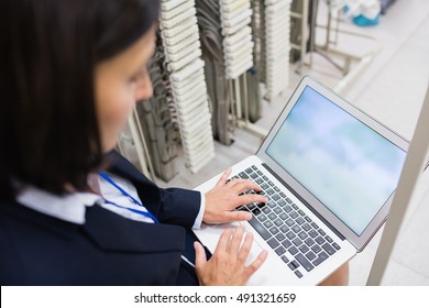 Attentive Technician Using Laptop In Server Room