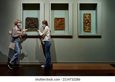 Attentive Tween Girl With Senior Woman Exploring Art Museum