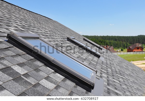 Attic skylight.\
Asphalt Shingles House Roofing Construction with Attic Roof\
windows, skylights\
waterproofing.