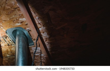 Attic View Of Installation Of A Galvanized Vent Pipe Through A Roof.