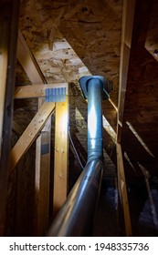 Attic View Of Installation Of A Galvanized Vent Pipe Through A Roof.