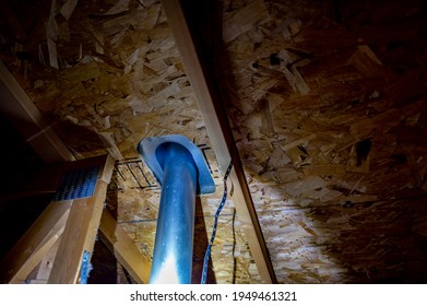 Attic View Of Installation Of A Galvanized Vent Pipe Through A Roof.