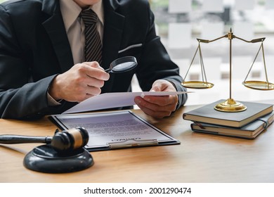 Attorney Or Judge Sitting At  Desk, Holding Magnifying Glass And Reading Book. Businessman, Business Auditor, Teacher, Professor Searching For Information, Fact-checking, Law Consulting Professional 