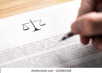 Attorney, lawyer, solicitor or jurist working on a business brief in law firm. Legal contract, clause or article paper. Man writing document with scale icon and sign with pen. Judge making decision. - Shutterstock ID 1210001428