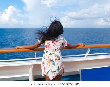 Attract African American Black Woman Girl On Ship Cruise Deck Looking At Blue Sea Ocean With Long Hair Blowing Out