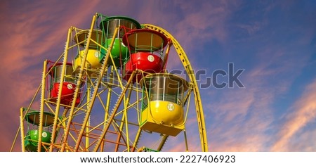 Attraction (carousel) ferris wheel against the background of a romantic evening sky 