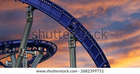 Attraction roller-coaster (switchback) against the background of a romantic evening sky 
