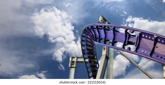 Attraction roller-coaster (switchback) on the background of the cloudy sky 