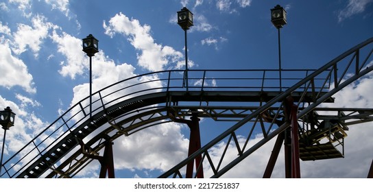Attraction roller-coaster (switchback) on the background of the cloudy sky 