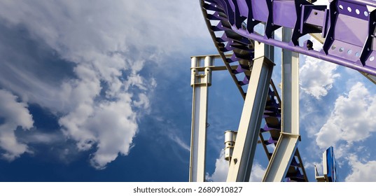 Attraction roller-coaster (switchback) on the background of the cloudy sky 