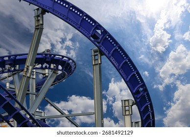 Attraction roller-coaster (switchback) on the background of the cloudy sky 