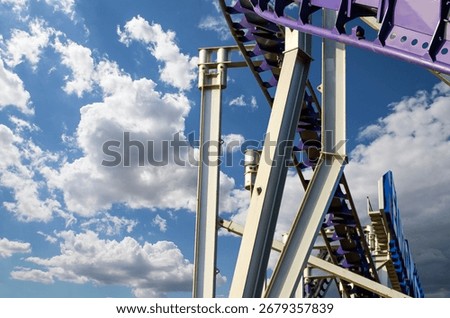 Attraction roller-coaster (switchback) on the background of the cloudy sky 