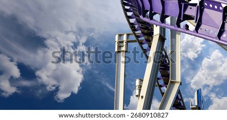 Attraction roller-coaster (switchback) on the background of the cloudy sky 