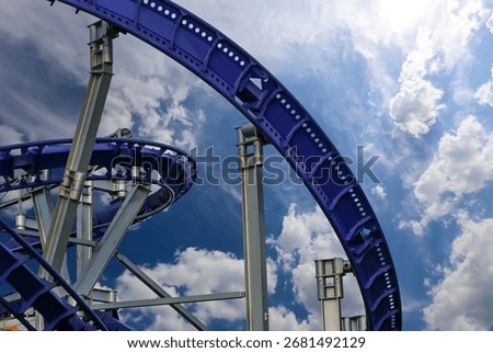 Attraction roller-coaster (switchback) on the background of the cloudy sky 