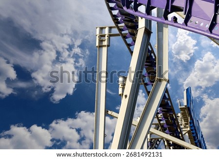 Attraction roller-coaster (switchback) on the background of the cloudy sky 