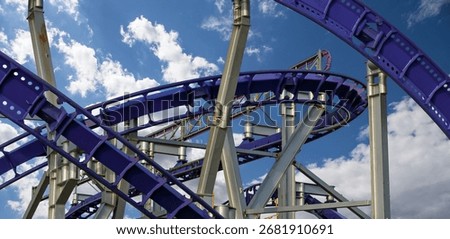 Attraction roller-coaster (switchback) on the background of the cloudy sky 
