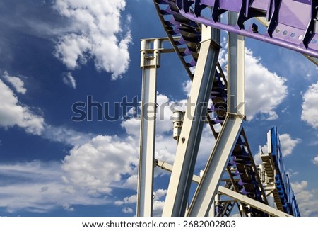 Attraction roller-coaster (switchback) on the background of the cloudy sky 