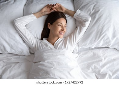 Attractive 30s Carefree Woman In Comfy Pyjamas Lying Down Alone In Comfortable Bed After Night Enough Sleeping Woke Up Feels Good Top View. Enjoy Fresh Bedding, New Sheet Hotel Room Vacation Concept