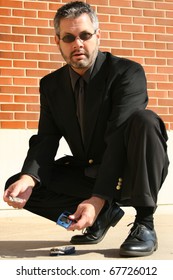 Attractive 40 Year Old Business Man Picking Up Broken Cellphone From Sidewalk.