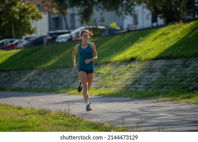 Attractive adn beautiufl fit girl is running and smiling on the track