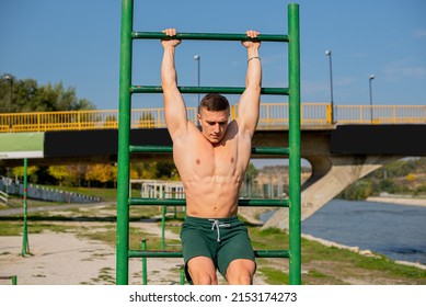 Attractive adn handsome strong guy is focusing on the exercise while being topless