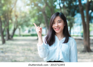 Attractive Adult Business Woman Asian Girl With Happy And Smile Standing With Finger Pointing On Walk Way Go To Working Between Her Office On Morning Under Green Forest.