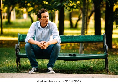 Attractive Adult Man Sitting Alone On Bench In Park