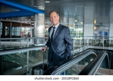 Attractive Adult Man With Suitcase On Airport Escalator