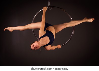 Attractive aerialist woman exercising on aerial ring (lyra) - Powered by Shutterstock