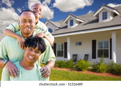 Attractive African American Family In Front Of Beautiful House.