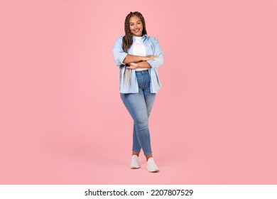 Attractive African American Female Posing Wearing Plus Size Clothes, Standing Crossing Hands And Smiling To Camera On Pink Background In Studio. Body Positive Concept. Full Length Shot