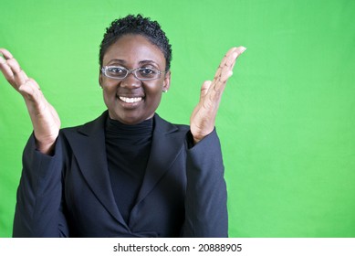 An attractive African American woman raising her hands as if excited or enthused.