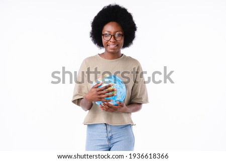 Attractive african teenager girl holding a globe with care isolated in white background