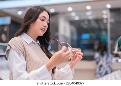 Attractive Asia Young Adult Female Woman Casual Cloth Spending Weekend Vacation Enjoy Choosing Glasses In Optical Store Shop She Is Pick The Favourite One For Herself