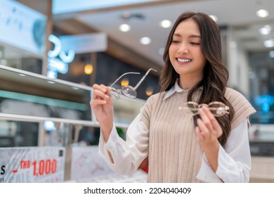 Attractive asia Young adult female woman casual cloth spending weekend vacation enjoy choosing glasses in optical store shop she is pick the favourite one for herself - Powered by Shutterstock