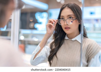 Attractive asia Young adult female woman casual cloth spending weekend vacation enjoy choosing glasses in optical store shop she is pick the favourite one for herself - Powered by Shutterstock