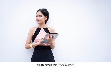 Attractive Asian Business Woman Standing Holding Tablet Computer And Face Smile Looking To Copy Space On Gray Clor Background, Hapiness Successful People Concept