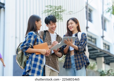 Attractive asian college student using laptop and tablet studying with group of friends together with english language classroom, social media and education concept. - Shutterstock ID 2256831465
