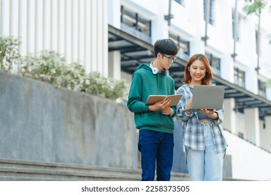 Attractive asian college student using laptop and tablet studying with group of friends together with english language classroom, social media and education concept. - Shutterstock ID 2258373505