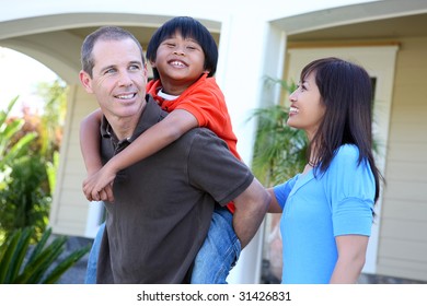 Attractive Asian Family Outside Their Home Having Fun