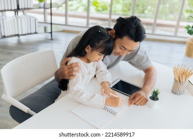 Attractive Asian Father Teaching Little Child Daughter Learning Studying Doing Homework At Home, Family Quality Time And E-learning Education Concept