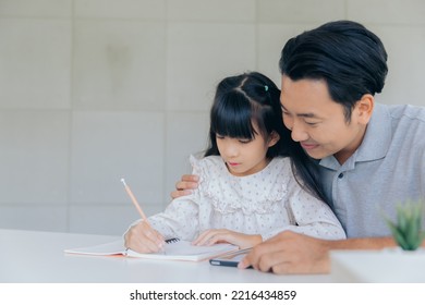 Attractive Asian Father Teaching Little Child Daughter Learning Studying Doing Homework At Home, Family Quality Time And E-learning Education Concept