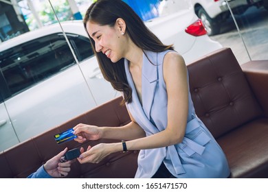 Attractive Asian Girl Millenials Buying A New Car With Credit Card. Film Effected. 