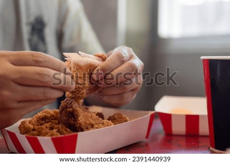 Attractive Asian man eating fried chicken