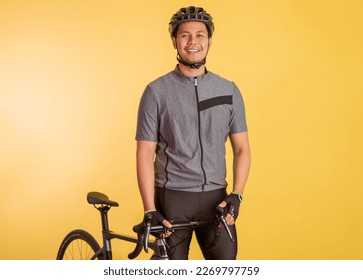 attractive asian man in sporty outfit standing holding the bicycle on isolated background - Powered by Shutterstock