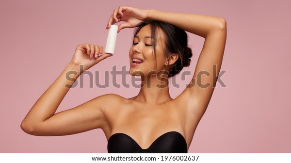 Attractive asian woman\
advertising for new cosmetic product. Female model promoting new\
skin care product.