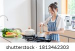 attractive asian woman cooking at kitchen